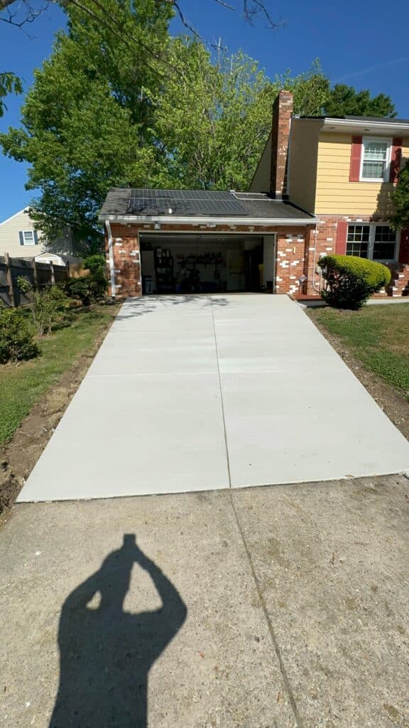 New concrete driveway leading up to a garage