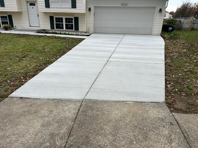 New concrete driveway meeting an older concrete sidewalk at the street